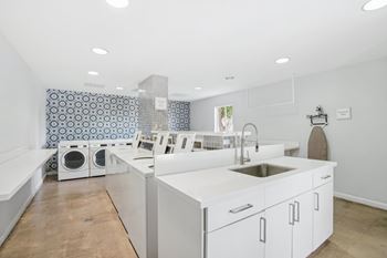 A kitchen with a white counter top and a sink.